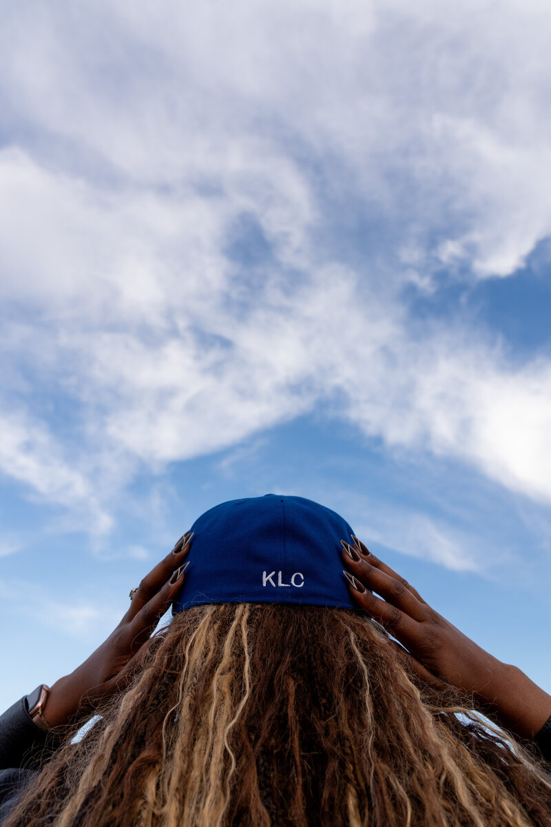 Kierra wearing a KLC cap, looking up at the sky